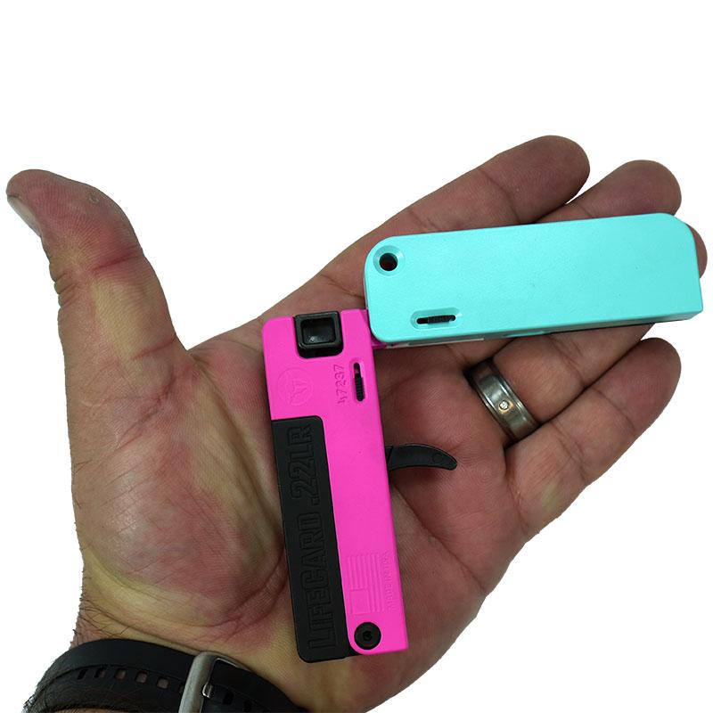 Photoreal 8K lifestyle shot of the LifeCard handgun held discreetly in a person's hand showing scale and credit-card thin profile, neutral studio backdrop, natural lighting